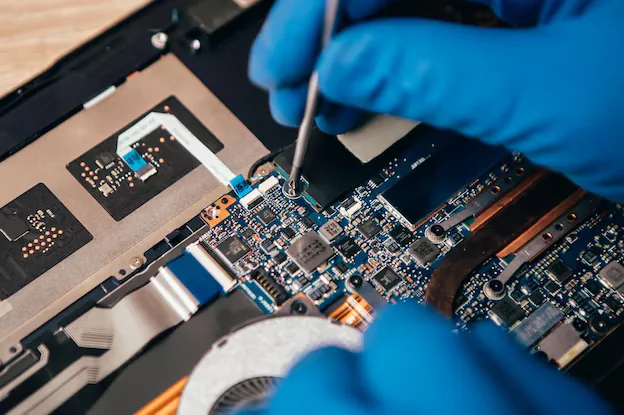 Laptop opened up on a bench with the motherboard exposed during a repair